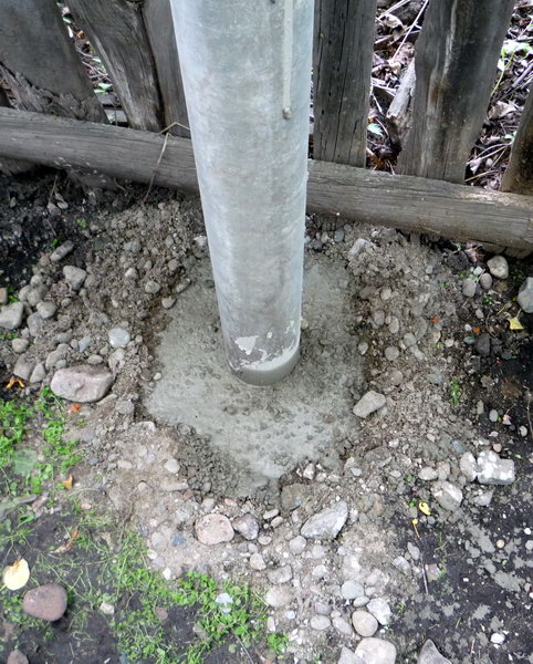 Забетонированная скважина с установленным заборным столбом